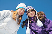 Two teenage girls in winter clothes, smiling at camera