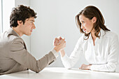 Businessman arm wrestling with a businesswoman
