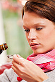 Young woman taking cough medicine