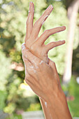 Close-up of woman's hands applying moisturizer