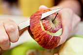 Close-up of man's hand peeling an apple