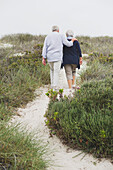 Rear view of a senior couple walking on the beach