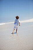 Rear view of a boy running on beach