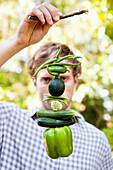 Man holding vegetables hanging on a twig