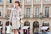 Woman walking with shopping bags on a street, Paris, Ile-de-France, France
