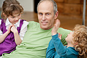 Man sitting with his grandchildren