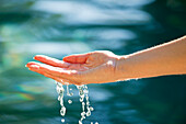 Close-up of a man's hand touching the water of the swimming pool
