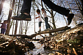 Children playing along the lakeshore, jumping over a stream, Leoni castle grounds, Leoni, Berg, Lake Starnberg, Bavaria, Germany