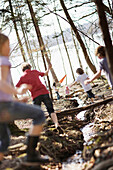 Children playing along the lakeshore, jumping over a stream, Leoni castle grounds, Leoni, Berg, Lake Starnberg, Bavaria, Germany