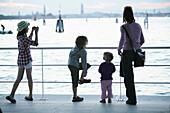 Family at the pier in Lido di Venezia, View towards Venice, Veneto, Italy