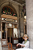 Old woman sitting in cafe Florian, Venice, Veneto, Italy