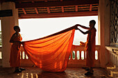 Junge Mönche, Novizen, legen ihre Robe zusammen, Phu Si Hügel, Luang Prabang, Laos, Südostasien, Asien