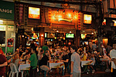 Toursiten sitzen am Abend an Tischen in der Khao San Road, Banglampoo, Bangkok, Thailand