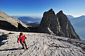 Woman walking towards Drittes Watzmannkind, Kleiner Watzmann, Zweites and Erstes Watzmannkind in background, Watzmann, Berchtesgaden National Park, Berchtesgaden Alps, Upper Bavaria, Bavaria, Germany