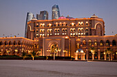 Strand und das Emirates Palace Hotel in der Abenddämmerung, mit Hochhäusern im Hintergrund, Abu Dhabi, Vereinigte Arabische Emirate