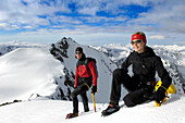 Zwei Kletterer auf einem Berggipfel rastend, Südtirol, Trentino-Alto Adige, Italien