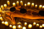 Eine Frau liegt im Kerzenkreis, Welnesshotel, Südtirol, Trentino-Alto Adige, Italien