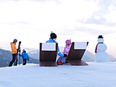Familie und Schneemann in verschneiter Landschaft, Alto Adige, Südtirol, Italien, Europa