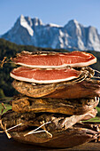 Ein Stapel Räucherspeck vor dem Schlernmassiv, Kastelruth, Alto Adige, Südtirol, Italien, Europa