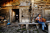 Senner spielt Ziehharmonika vor seiner Hütte, Schnalstal, Alto Adige, Südtirol, Italien