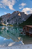 Reflection of mountains on lake Pragser Wildsee at dusk, Nature Park Fanes Sennes Prags, South Tyrol, Alto Adige, Italy, Europe