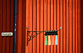 Colourful house sign outside wooden building painted in Falu red, Mariefred, Sweden