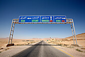 Road sign above desert highway, Syria