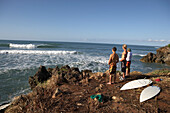 Three surfers looking out to sea, Tanzania