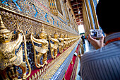 Man taking pictures on the bot of Wat Phra Kaeo, Bangkok, Thailand