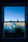 Looking out window of house to the harbor of Mousehole, Cornwall, England