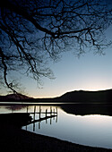 Silhouette of pier on lake at Derwent Water, Lake District, Cumbria, England