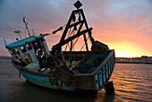 Fishing boat on the shore at sunset, Appledore, North Devon, England