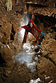 Speleology, caving, caver walking up an underground river, Ain Libné  (Lebanon)
