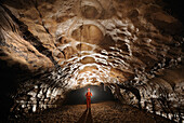 Speleology, caving, caver in a gallery, Grotte de la Cocalière, Gard, France