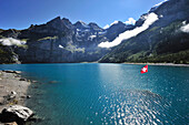 Swiss flag in Oeschinen Lake, Bluemlisalp, UNESCO World Heritage Site Jungfrau-Aletsch protected area, Bernese Oberland, canton of Bern, Switzerland