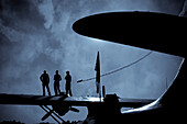 Three Men Atop PBY Airboat Wing, Silhouette