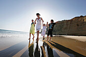 Mother and children walking on the beach, Conil de la Frontera, Costa de la Luz, Andalusia, Spain