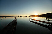 Child on a wooden jetty at sunset, Lake Woerthsee, Starnberg, Upper Bavaria, Bavaria, Germany
