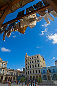 Washing drying under building roof with Plaza Vieja in background, Havana, Cuba