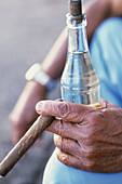 Man holding a bottle of rum and cigar, close-up, Havana, Cuba