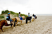Children at riding horses at the Ridecenter Vinterlejegaard situated in a dune landscape on the isthmus Holmsland Klit, West Jutland Denmark