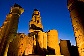 Colonnade of Amenophis III with statue of Ramses II at dusk, Luxor Temple, Luxor, Egypt