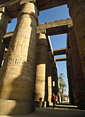 Woman walking through Great Hypostyle Hall, Temple of Amun, Karnak, Luxor, Egypt