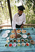 Waiter setting out buffet at outdoor table, Madhya Pradeshi, India