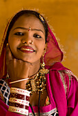 Smiling woman in traditional Rajasthani sari and jewellery, Jaipur, Rajasthan, India
