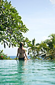 Young woman by hotel swimming pool, Balangan, Bali, Indonesia