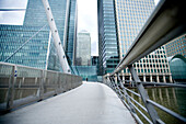 Walkways, buildings and bridge over waterways, Londons Docklands. Canary Wharf, London, England