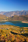 Blick auf Kalterer See mit herbstlich verfärbten Weinbergen und Dolomiten im Hintergrund, Kalterer See, Südtirol, Italien, Europa