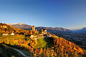 Castle Schloss Tirol with vineyards in autumn colours, Sarntal range and Meran in background, Schloss Tirol, Meran, South Tyrol, Italy, Europe