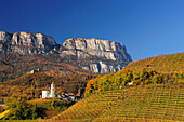 Vineyards in autumn colours with church, castle and rockface in background, Eppan, South Tyrol, Italy, Europe